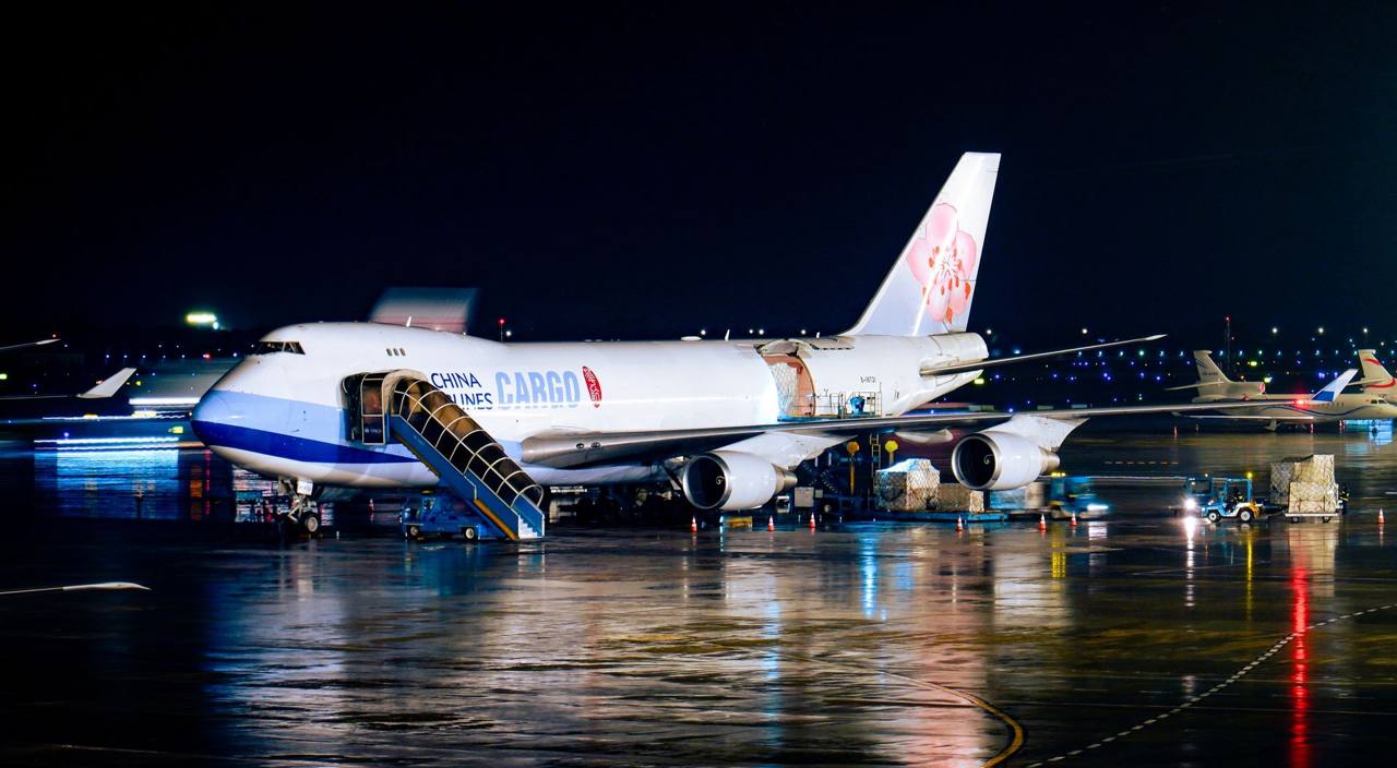 Cargo aircraft being loaded at night at an airport